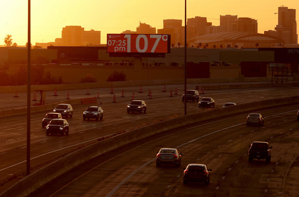 A billboard over a highway with cars and a setting sun (Justin Sullivan / Getty Images file)