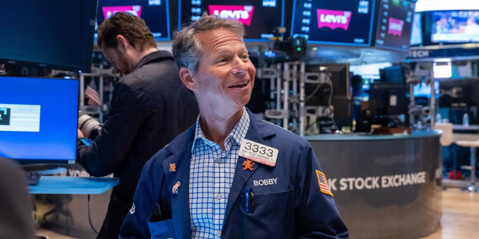 A smiling trader on the floor of the New York Stock Exchange.