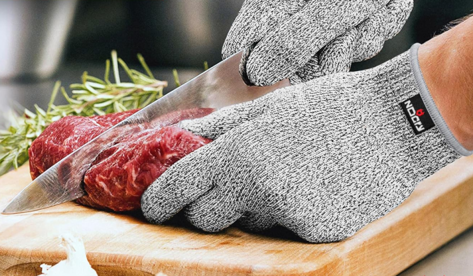 hands wearing the cut-resistant gloves while slicing meat