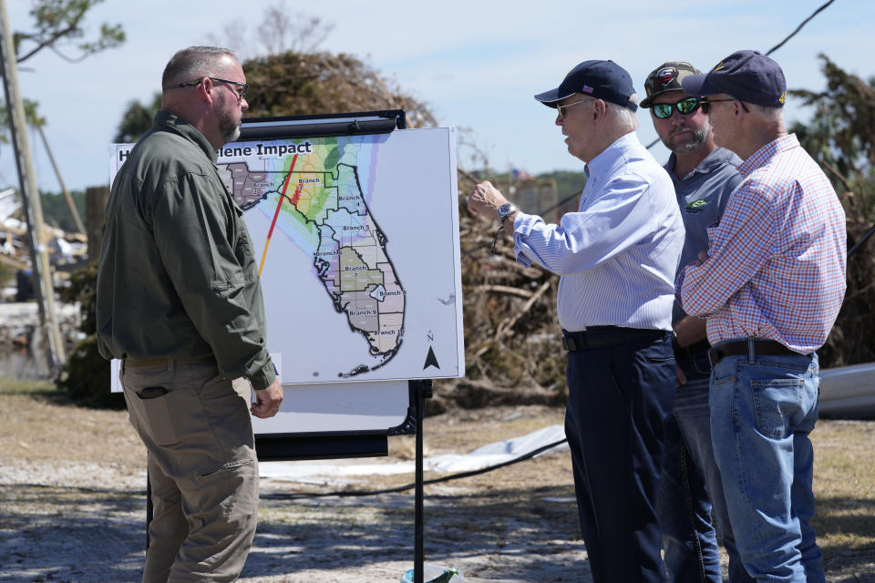 President Joe Biden receives an operational briefing from Director John Louk, Director of Emergency Management, Taylor County, Florida, on the damage from Hurricane Helene in Keaton Beach, Fla., Thursday, Oct. 3, 2024, as Sen. Rick Scott, R-Fla., right, looks on. (AP Photo/Susan Walsh)