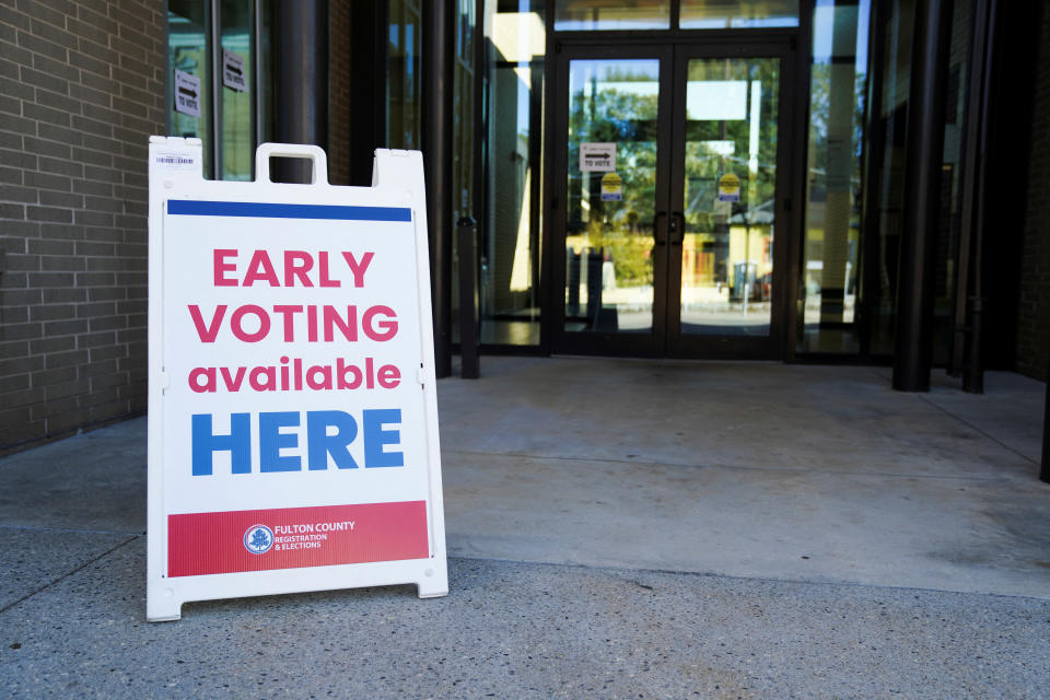 A sign outside a building reads: Early voting available here.