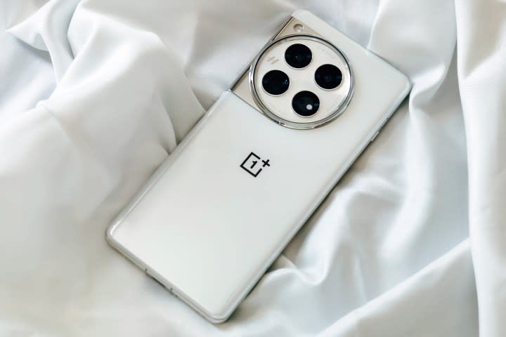 OnePlus 12 Glacial White on a wrinkly satin white cloth.