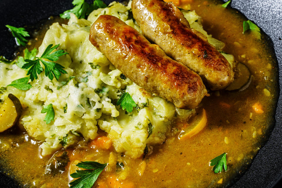 Close-up of dutch stamppot of potatoes, kale and sausages with gravy on plate