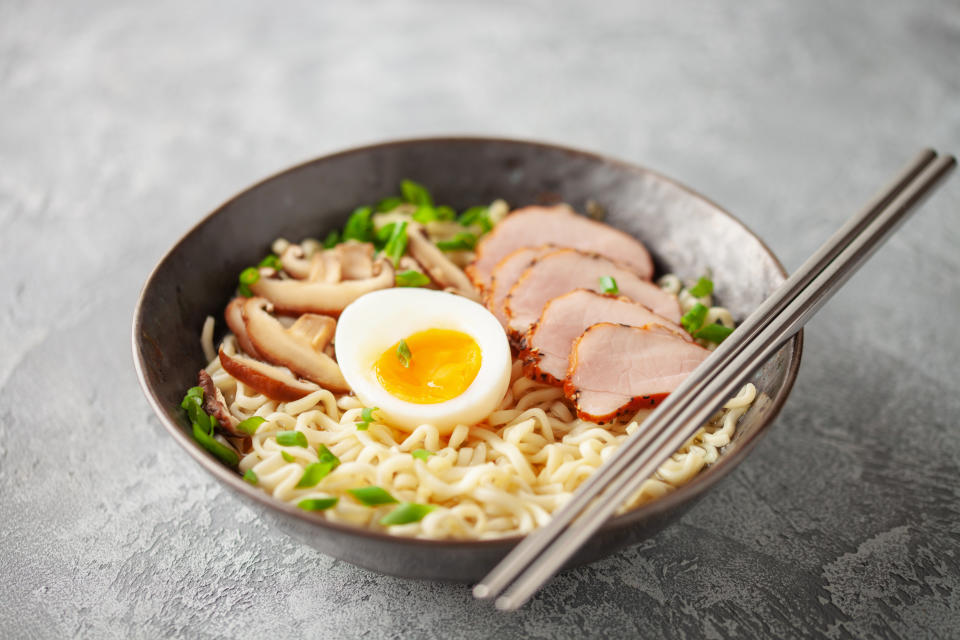 Japanese ramen noodles with pork slice, shiitake mushrooms and egg in a black bowl