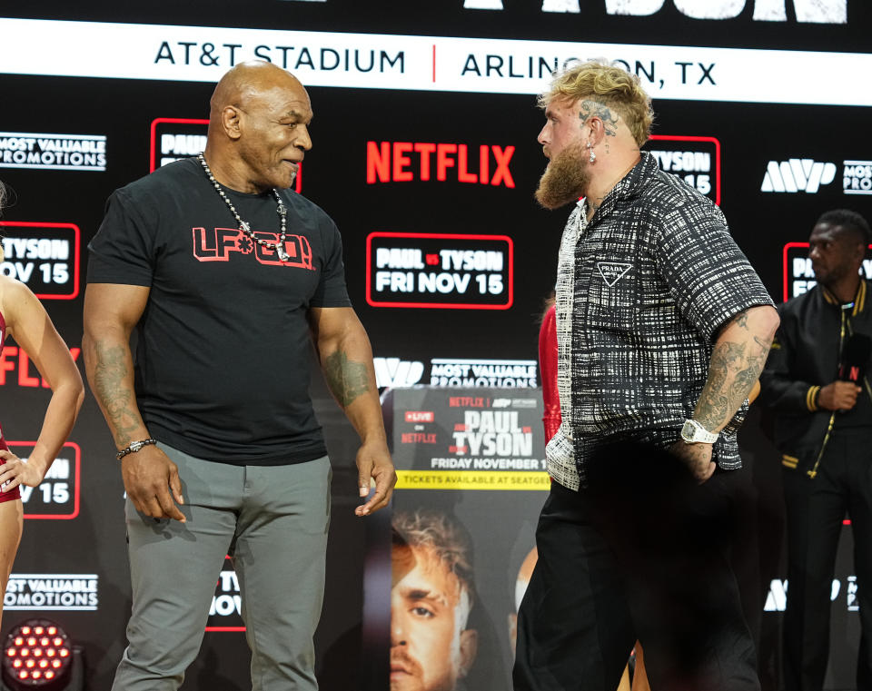 Mike Tyson and Jake Paul face off in front of a wall at the AT&T Stadium in Arlington, Texas.