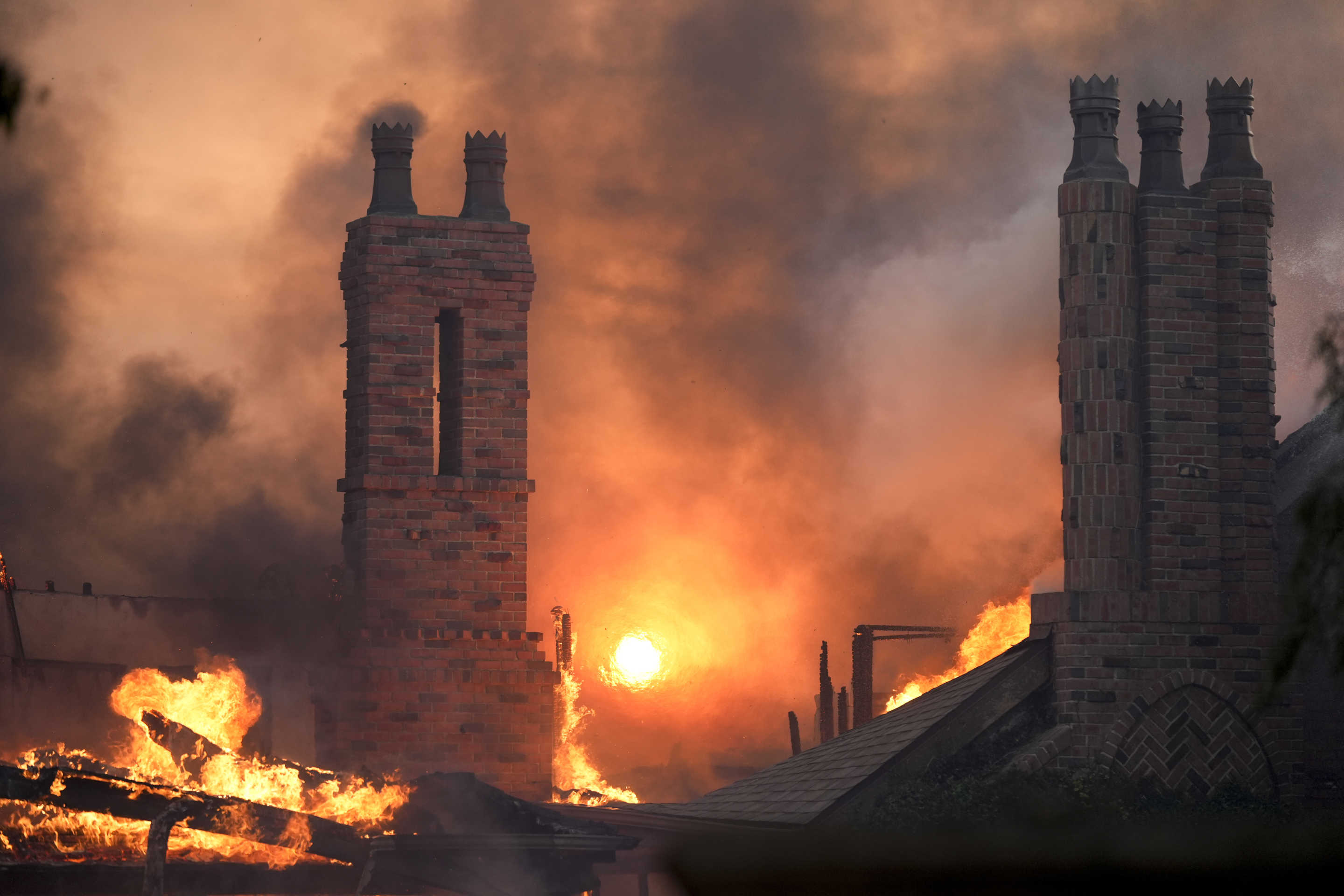 Flames from the Mountain Fire intensify as they engulf a structure in Camarillo, Calif. 