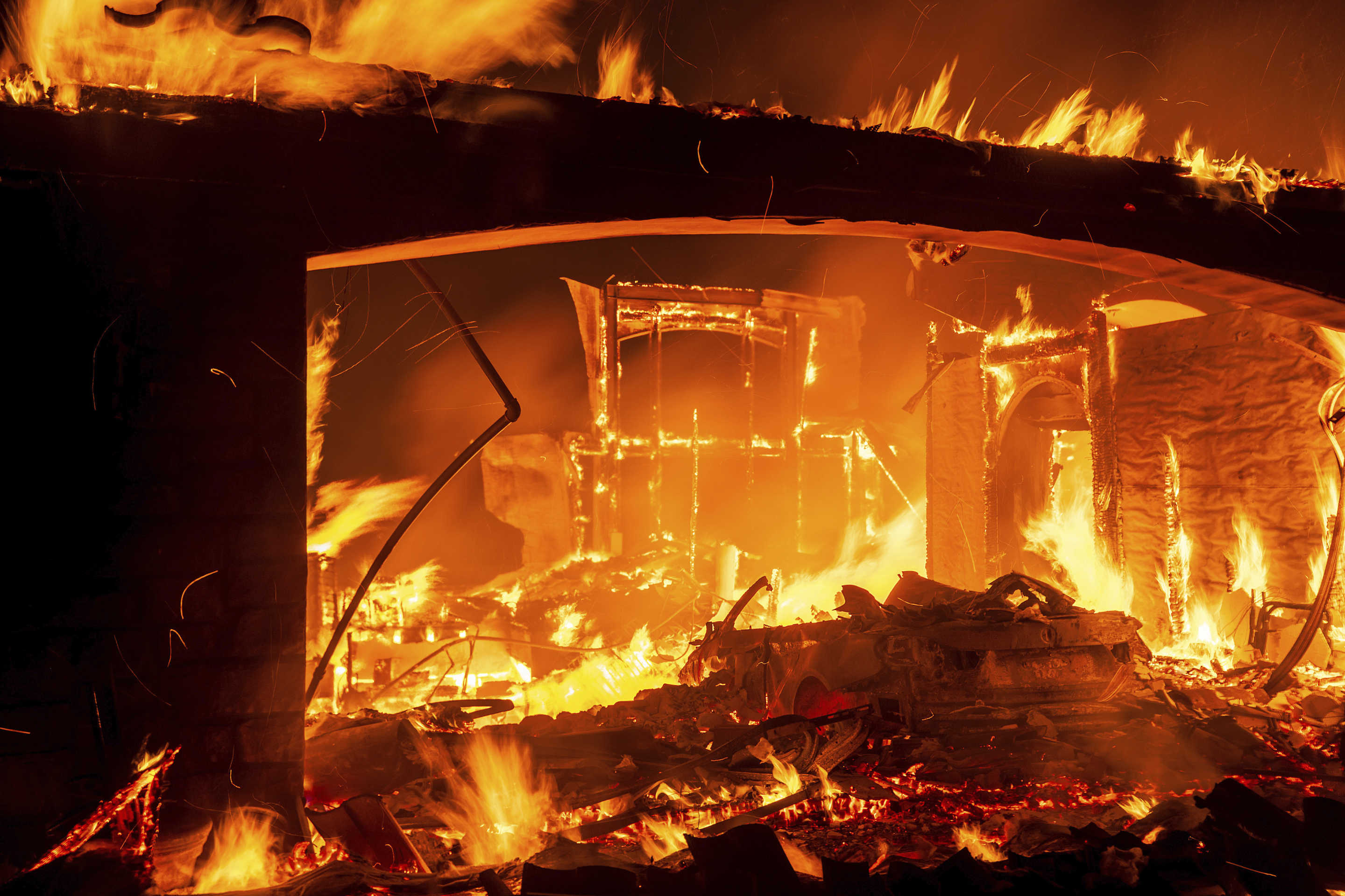 Flames consume a home as the Mountain Fire burns in Camarillo, Calif. 