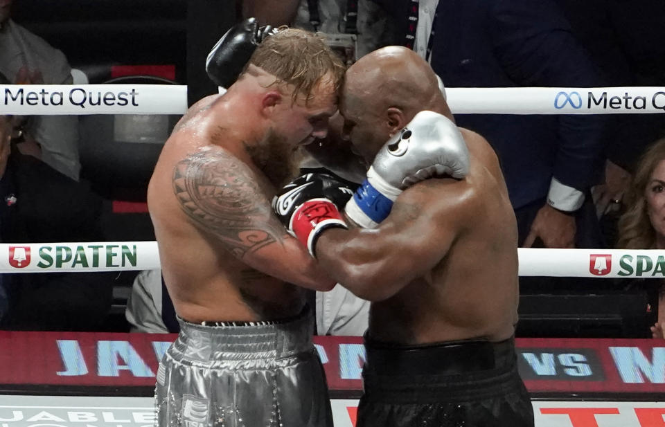 Jake Paul and Mike Tyson hug at the end of their heavyweight boxing bout.