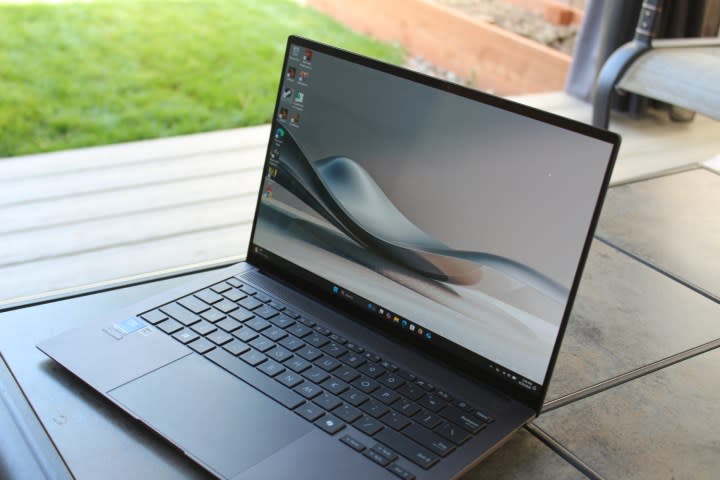 The Zenbook S 14 on a table in front of a grass lawn.