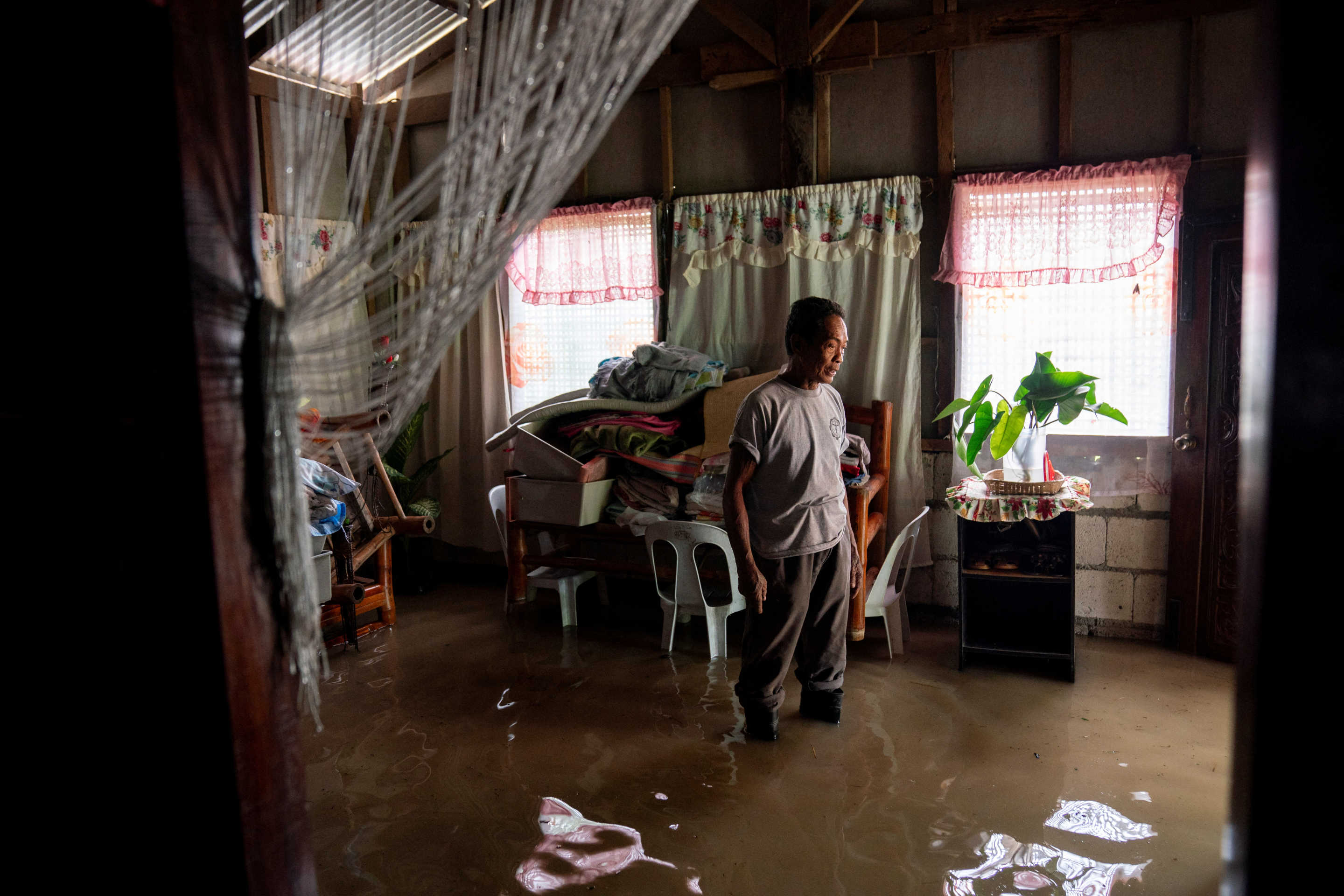 Danilo Dagdagan stands inside his flooded house following super typhoon Man-yi, in Quezon town, Nueva Ecija.