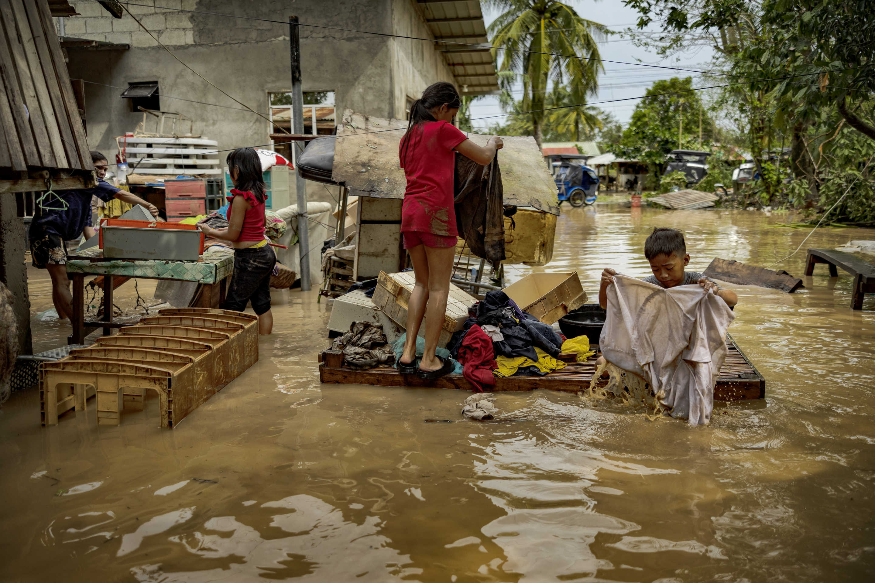 Children wash muddied clothes after they were flooded by Super Typhoon Man-yi in Bayombong.