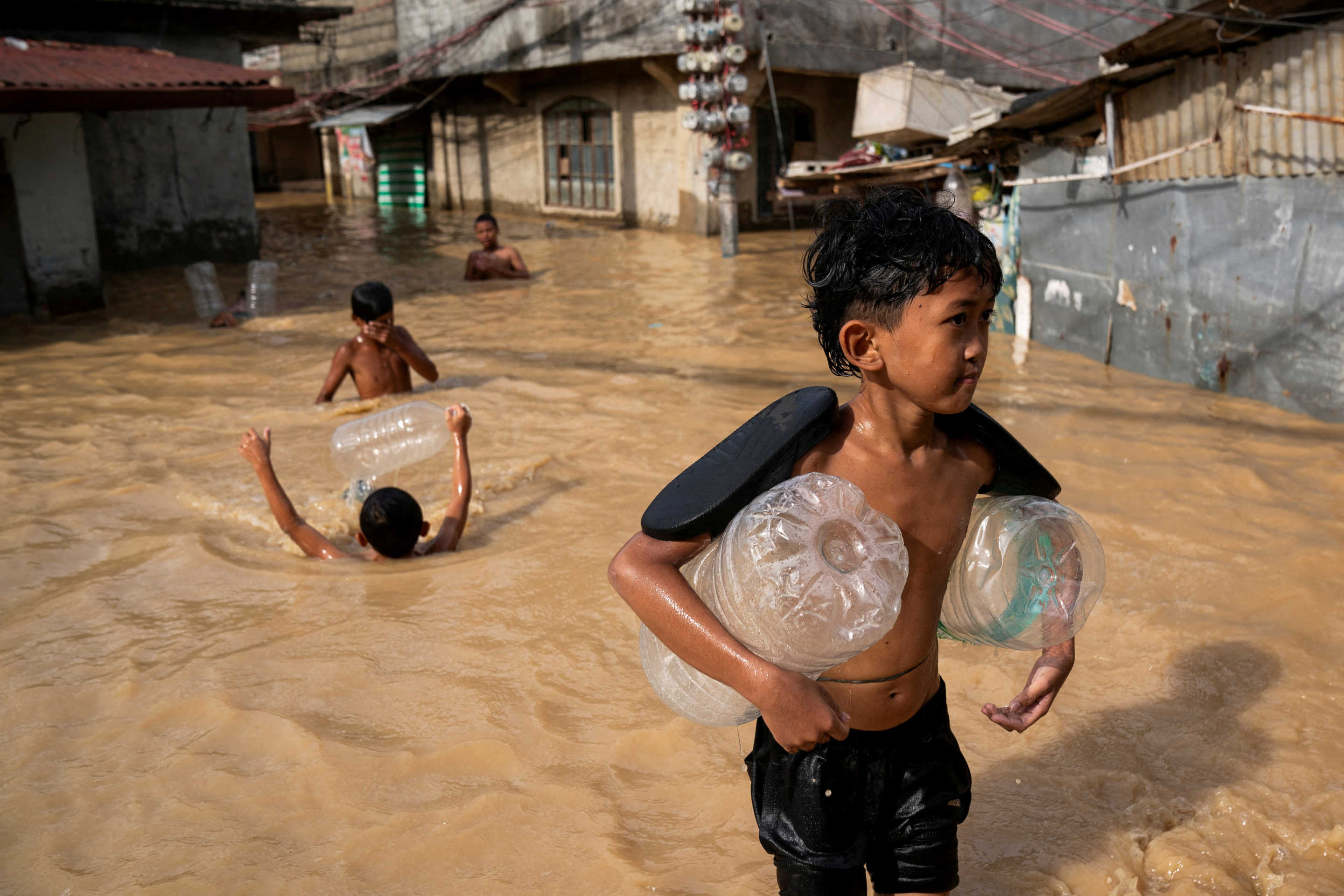 Children play along a flooded street following Super Typhoon Man-yi, in Cabanatuan, Nueva Ecija.