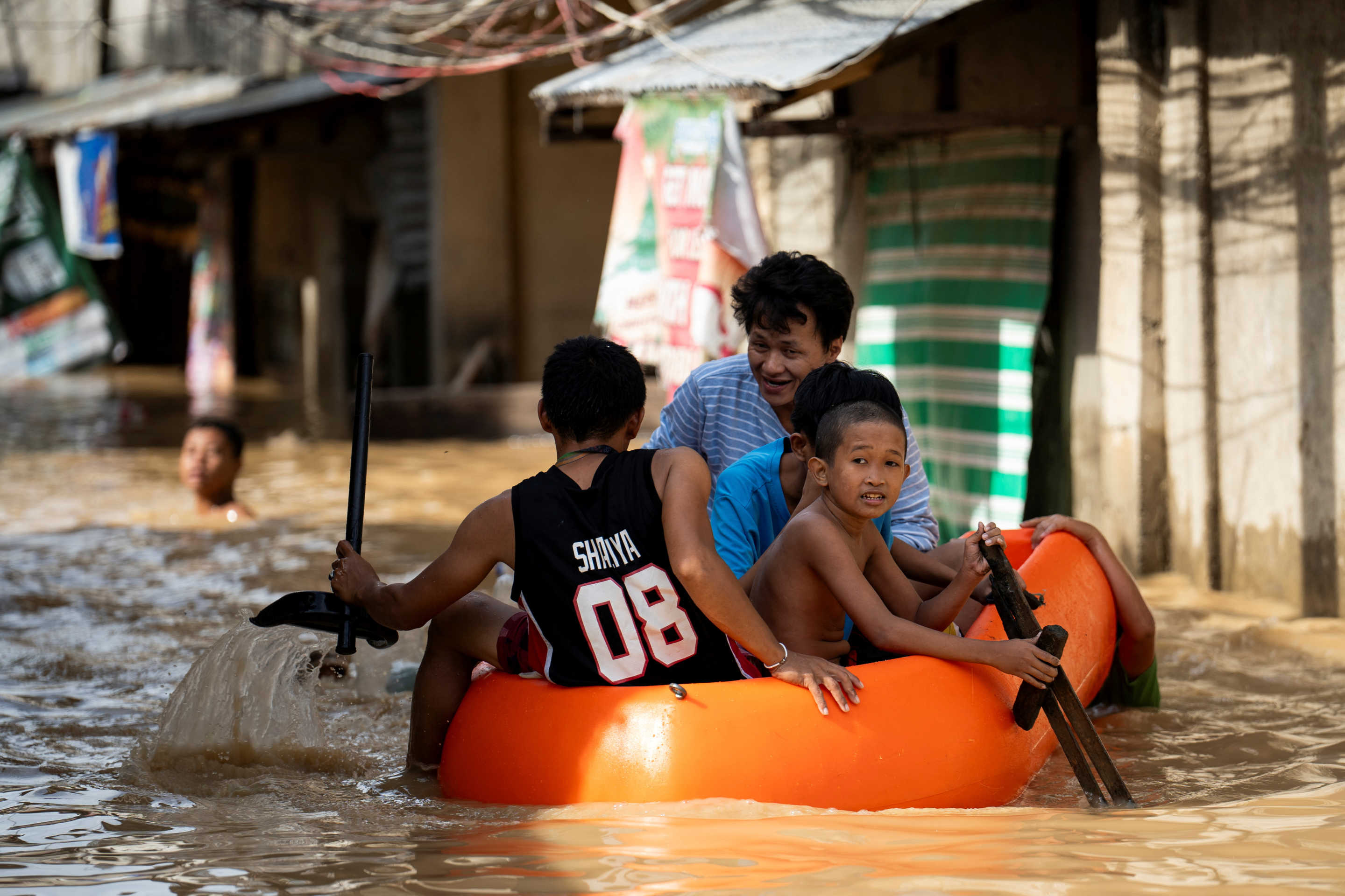 People ride on a rescue boat along a flooded street following super typhoon Man-Yi, in Cabanatuan, Nueva Ecija.