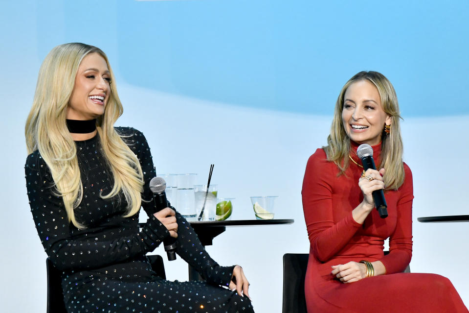 Paris Hilton and Nicole Richie hold microphones as they sit onstage during Vulture Festival.