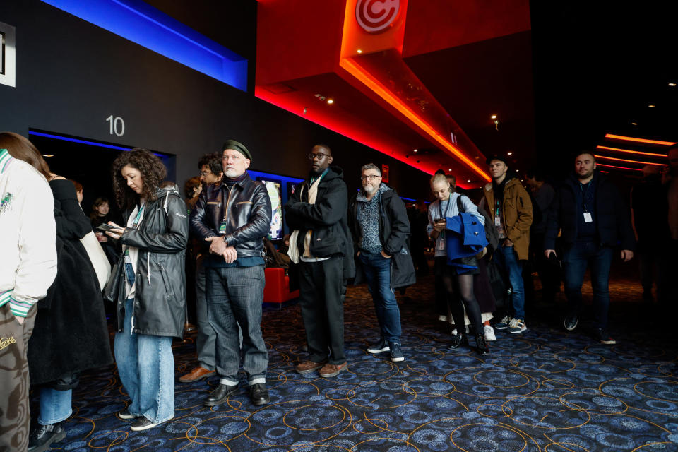 People waiting in a line at a cinema to watch the movie 