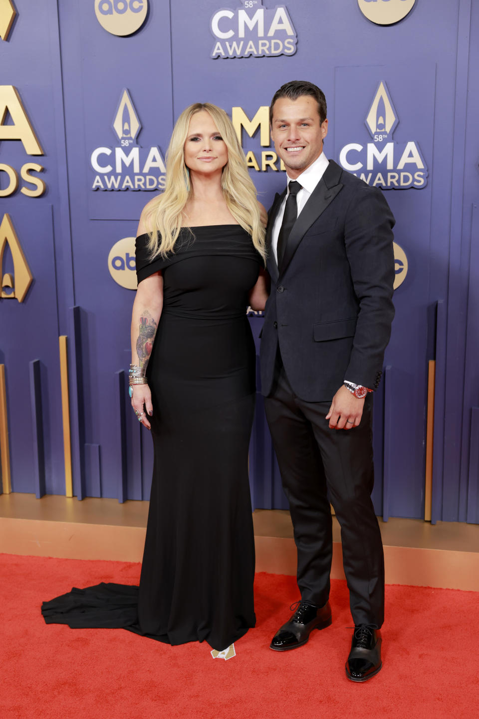 Miranda Lambert with a long black gown pooling behind her and Brendan McLoughlin in a black suit and tie. 