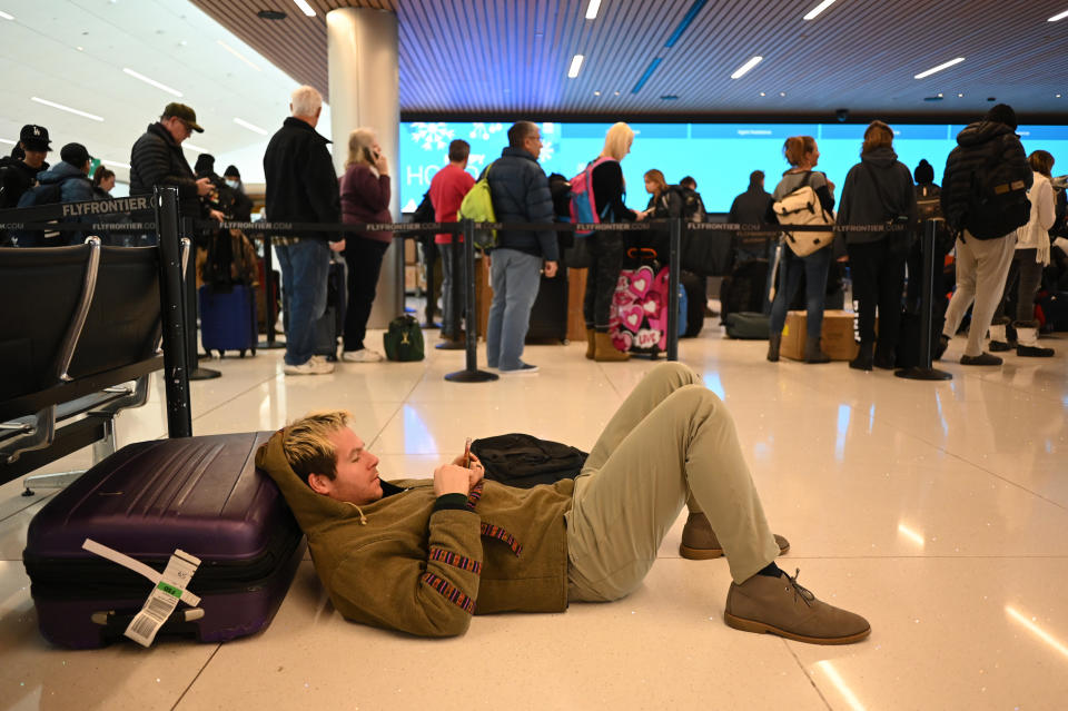 A man checks his cellphone at Denver International Airport after his flight was canceled on Dec. 22, 2022.