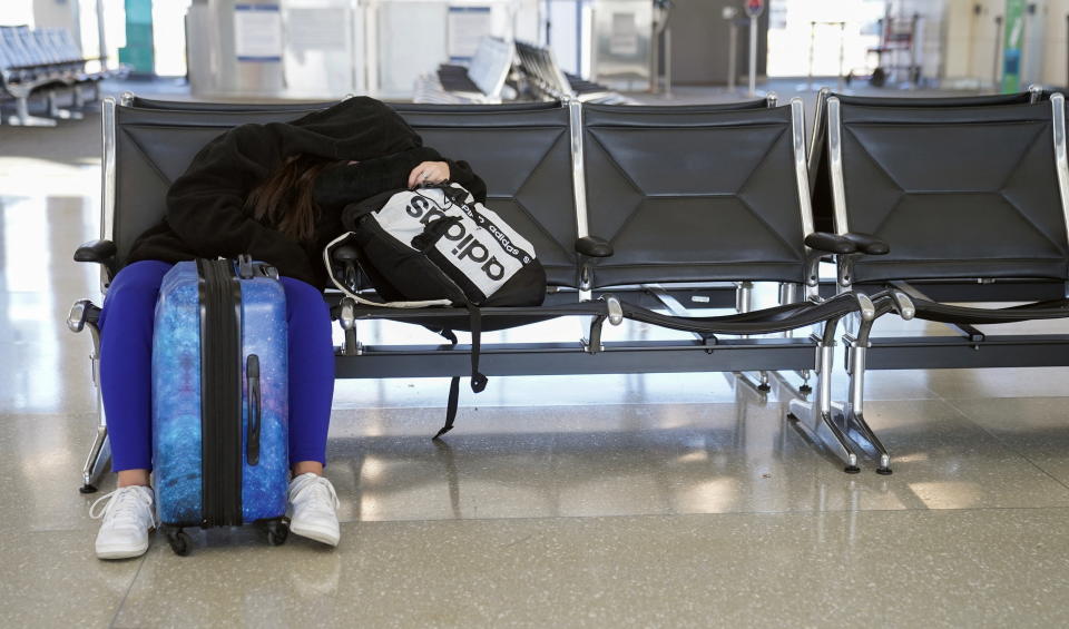 A passenger sleeps in the departure area at Washington Dulles International Airport in Virginia on Nov. 22, 2023.