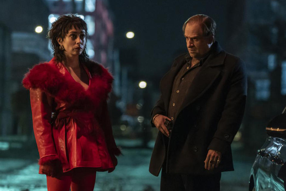 Cristin Milioti and Colin Farrell stand on a sidewalk in a scene from The Penguin. 