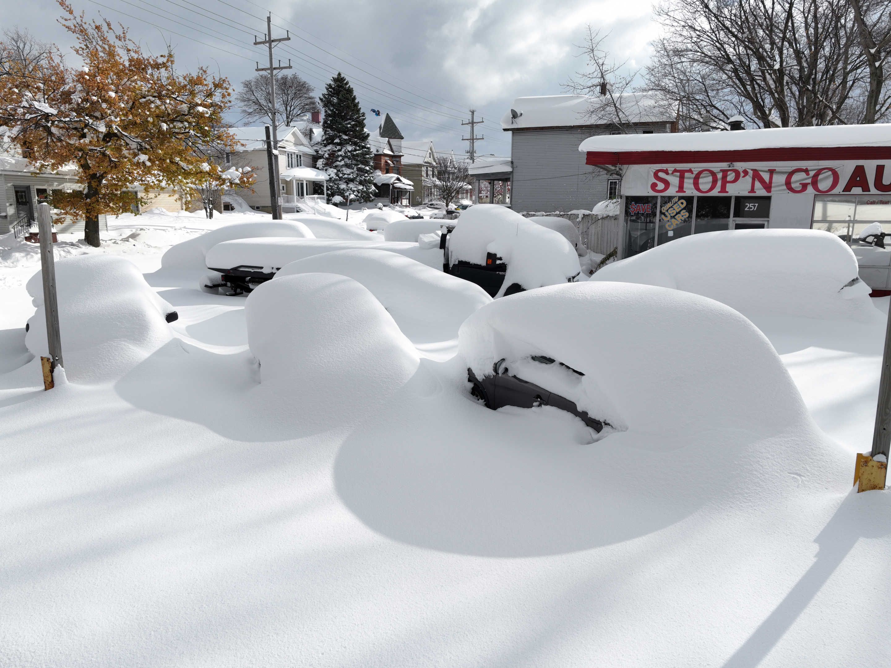 Lake-effect snow has accumulated and blankets an area near a store in the Great Lakes region.