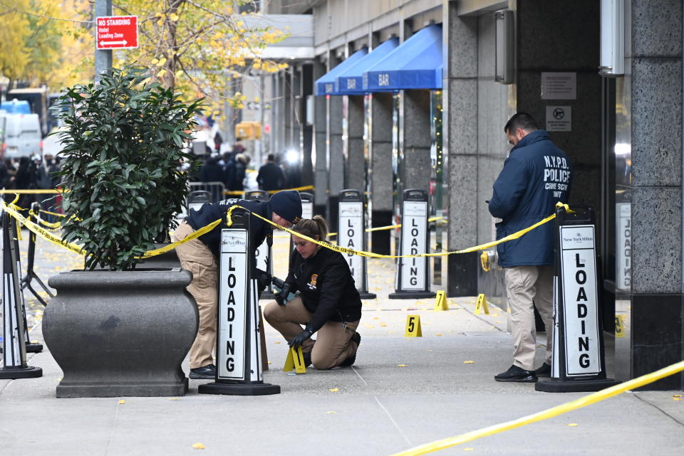 Police officers investigate the scene where UnitedHealthcare CEO Brian Thompson was fatally shot in Manhattan on Wednesday. (Kyle Mazza/Anadolu via Getty Images)