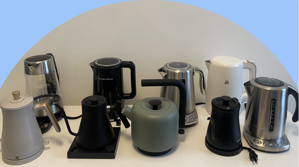 Nine electric kettles lined up in two rows on a white table