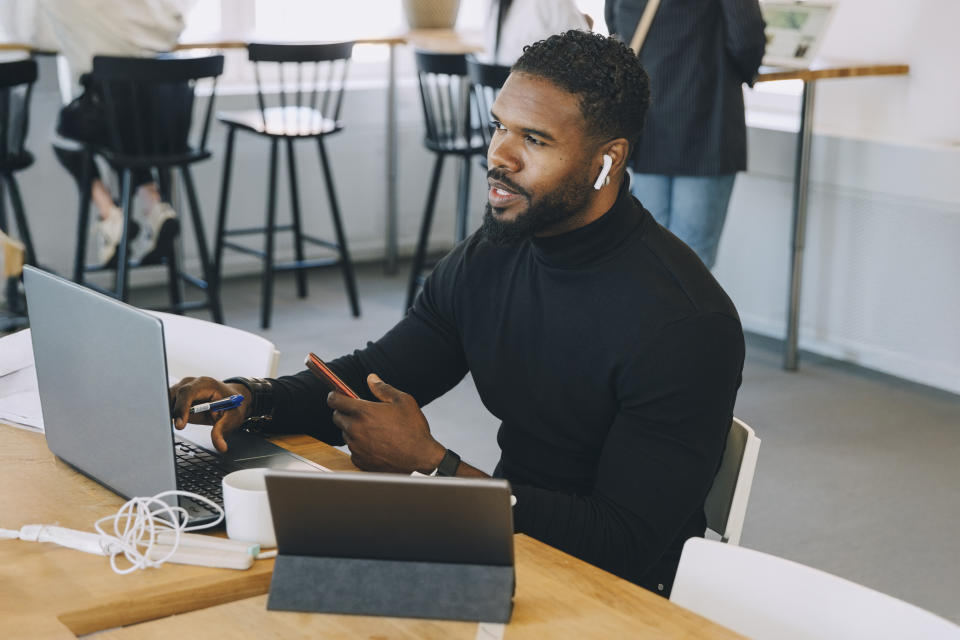 Man at a laptop wearing AirPods