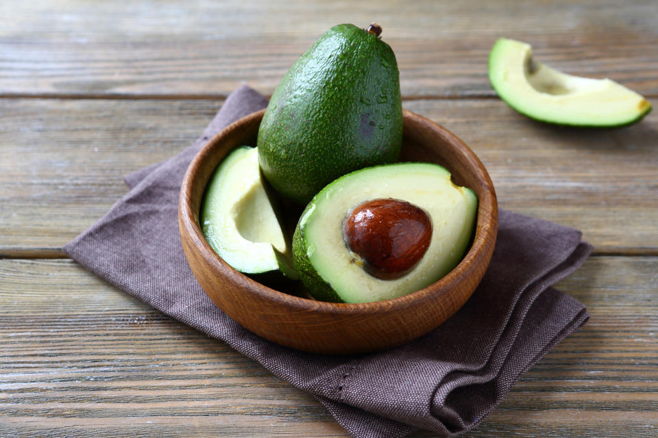 Avocados in a wooden bowl.