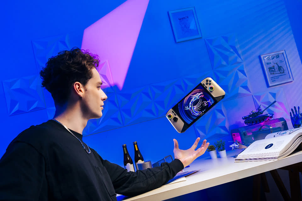 Product lifestyle image of a gamer in a blue and purple room floating the MSI Claw in the air like a Jedi.