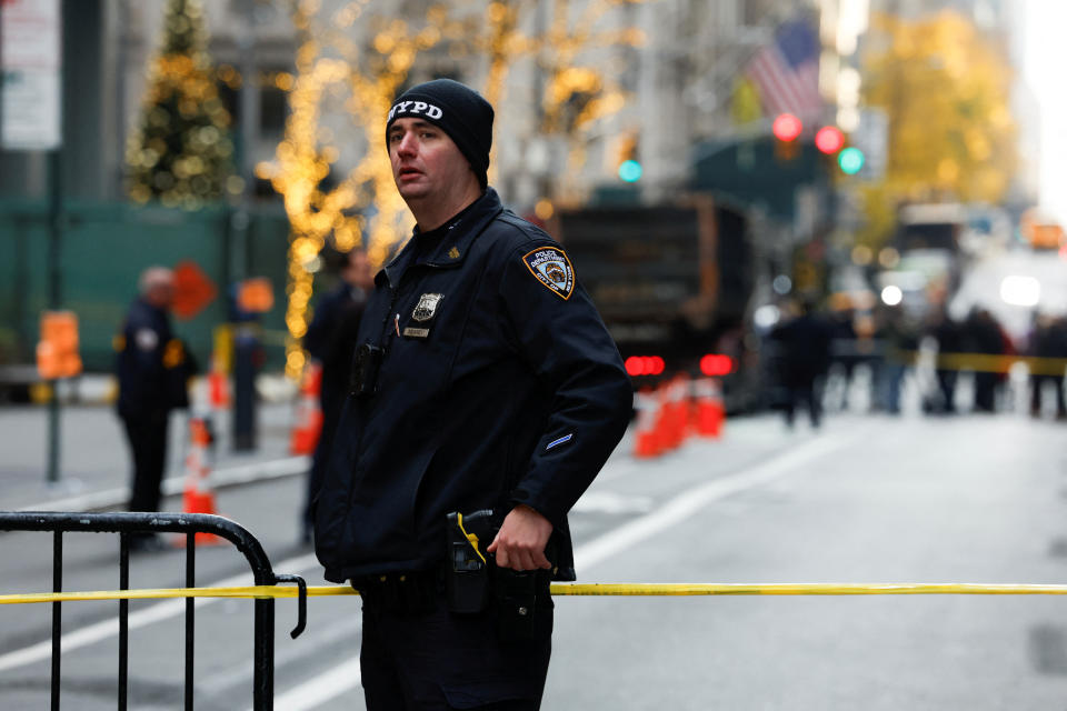 A police officer stands near the scene where the CEO of United Healthcare Brian Thompson was fatally shot in Manhattan Wednesday (Shannon Stapleton/Reuters)