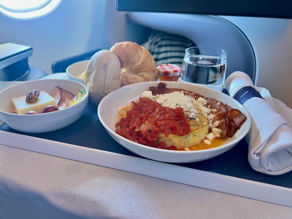 Breakfast service in Finnair’s business class, offering a full spread with fresh bread, cheese, eggs, and bacon to fuel the start of the day.