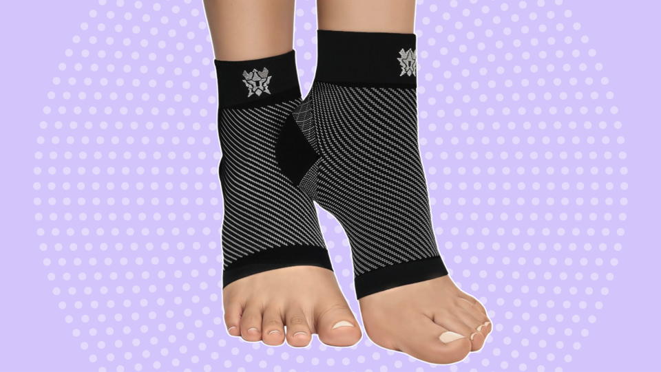 feet wearing compression socks over purple background