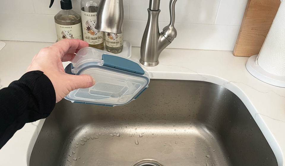 A Joseph Joseph food storage container is shown filled with water, sealed and tipped upside down to demonstrate that it's leak-proof