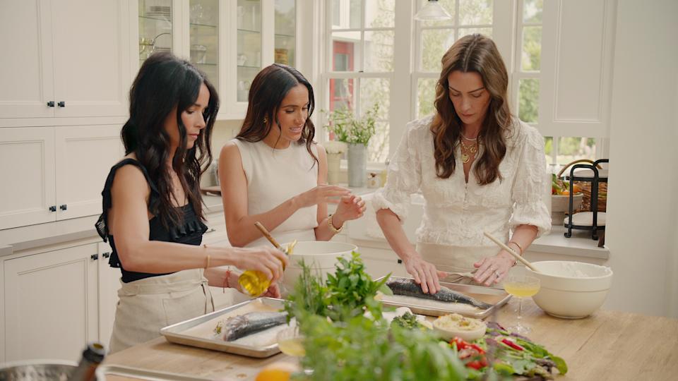 From left: Abigail Spencer, Markle and Kelly Zafjen in the kitchen prepping a meal.