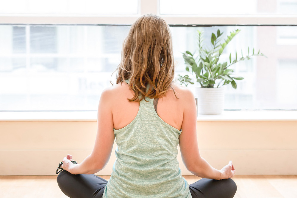 امرأة تقوم بالعصف الذهني لنشر أفكار مدونة اليوغا على الكمبيوتر المحمول