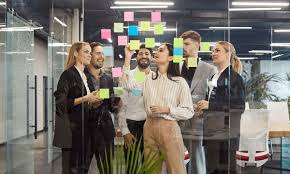 Two Sonos Play speakers positioned on grass in front of a sage colored bag in a 2026 setting